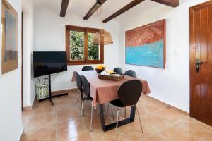 comedor con mesa, sillas y TV en Villa Marta, en Denia