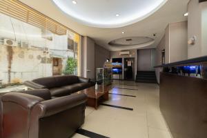 a living room with leather furniture and a lobby at RedDoorz at Jalan Gunung Sahari in Jakarta