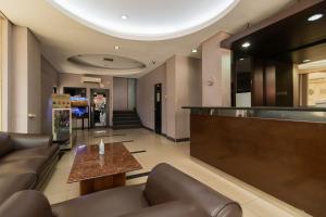 a lobby with leather furniture and a bar at RedDoorz at Jalan Gunung Sahari in Jakarta