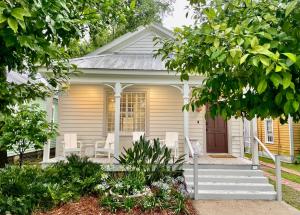 uma casa branca com um alpendre com cadeiras brancas em Elegance & Charm 27 Steps To Old Christ Church em Pensacola