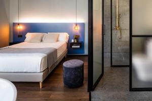 En eller flere senge i et værelse på Muralla Sevilla Suites By Lola