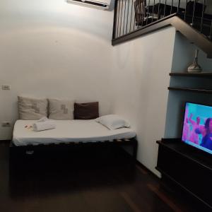 mały pokój z łóżkiem i telewizorem w obiekcie San Giovanni Lovely Loft w Rzymie