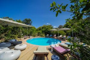 uma piscina num deque de madeira com cadeiras e guarda-sóis em Thonga Beach Lodge em Mabibi