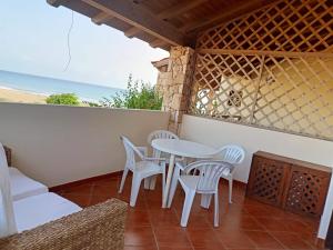 a table and chairs on a balcony with the beach at Sal&Love apt in Porto Antigo in Santa Maria