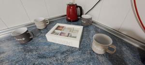 a box of mugs sitting on a counter with cups at Apartamento Jarrillero in Portugalete