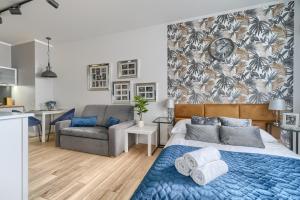 シュチェチンにあるEXCLUSIVE Nautica Apartmentsのベッドルーム(ベッド1台、ソファ付)