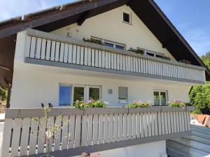 a house with a balcony with flowers on it at Steepleview House, Schwarzwaldblick Apartment - spacious & peaceful in Bad Peterstal-Griesbach