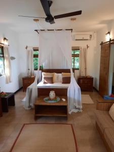 a living room with a bed and a table at Domaine Les Rochers in La Digue