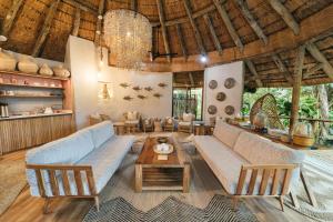 uma sala de estar com um sofá, cadeiras e uma mesa em Thonga Beach Lodge em Mabibi