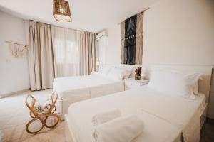 Habitación de hotel con 2 camas y ventana en Drymades Bungalows Adults Only en Dhërmi