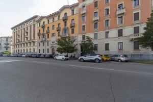 a street with cars parked in front of buildings at House Brembo in Milan