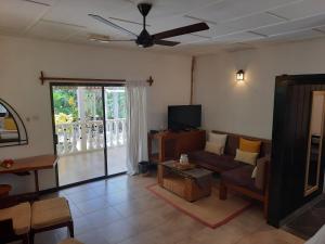 a living room with a couch and a tv at Domaine Les Rochers in La Digue