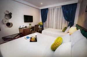 une chambre d'hôtel avec un lit blanc et un canapé dans l'établissement Aviary Hanoi Hotel & Travel, à Hanoï