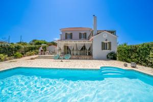 a villa with a swimming pool in front of a house at Villa Edem in Khalikerí