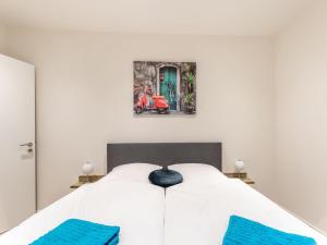 1 dormitorio con cama blanca y almohadas azules en Farmhouse in the Achterhoek with hot tub and beach volleyball en Megchelen