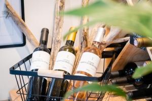 uma cesta cheia de garrafas de vinho sobre uma mesa em The Originals City, Hôtel Le Pavillon, Béziers Est em Béziers