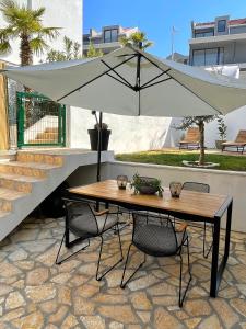 een tafel en stoelen met een parasol op een patio bij Great outdoor living steps away from the beach in Sutivan