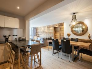Una cocina y un comedor con mesa y sillas. en Lodge 4****, 8 voyageurs, Sauna, Balcon, Accès internet, Parking - FR-1-304-217, en La Clusaz 7 fotos más