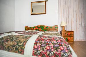 1 dormitorio con 1 cama con una manta colorida en Ostoja Wigierski, en Mikolajewo