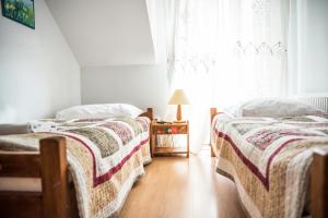 two beds in a room with a window at Ostoja Wigierski in Mikolajewo