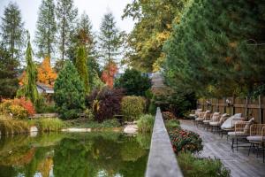 ミコワイェボにあるOstoja Wigierskiの池と椅子、木々のある庭園
