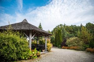 a wooden gazebo in the middle of a garden at Ostoja Wigierski in Mikolajewo