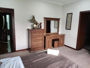 una camera con cassettiera, specchio e letto di Al Mirjon a Bukhara