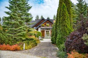 a house surrounded by trees and a stone driveway at Ostoja Wigierski in Mikolajewo