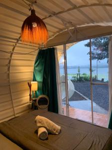 a bed in a room with a view of the ocean at Glamour camping bedugul in Bedugul