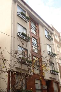 un edificio con ventanas y un árbol delante de él en TownHouse Istanbul, en Estambul
