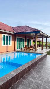 a swimming pool in front of a house at BUNGALOW D'CENANG- Private Pool in Pantai Cenang