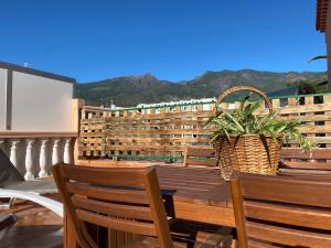 Un balcón con una mesa de madera, sillas y una planta en Casa Mariet, en La Hidalga