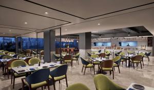 a restaurant with tables and chairs and a bar at Hyatt Place Vadodara in Vadodara