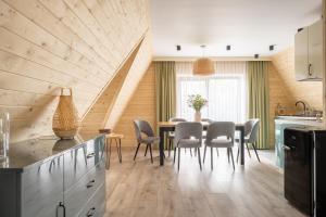 a kitchen and dining room with a table and chairs at Apartamenty Harenda Zakopane in Zakopane