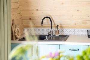 uma cozinha com um lavatório e paredes de madeira em Apartamenty Harenda Zakopane em Zakopane