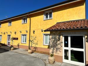 a yellow building with white doors and windows at Hotel Grahor Depandance in Sežana