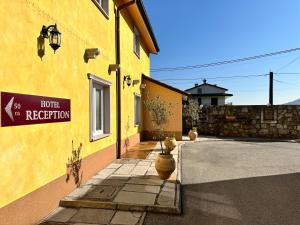 a yellow building with a sign on the side of it at Hotel Grahor Depandance in Sežana