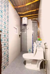 baño con aseo blanco en una habitación en ROSES HOUSE OMAN 2 en Al ‘Aqar