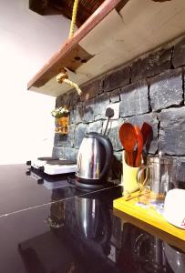 a kitchen counter with a tea kettle and utensils at ROSES HOUSE OMAN 2 in Al ‘Aqar