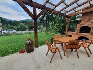 a wooden table and chairs on a patio with a fireplace at Magic Rooms in Gura Teghii