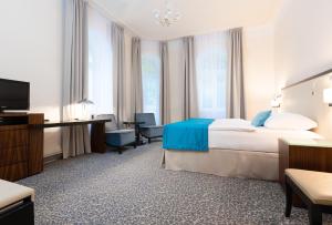 a hotel room with a bed and a television at OREA Spa Hotel Bohemia Mariánské Lázně in Mariánské Lázně