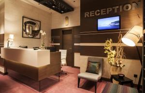 a lobby with a reception desk and a television on the wall at Atera Business Suites in Belgrade