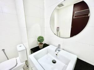 a white bathroom with a sink and a mirror at E 1-5Pax Cozy home 4 Bed Wifi TV Trefoil @Setia City Setia Alam SCCC in Setia Alam +8 photos