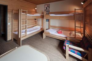 a room with three bunk beds in a cabin at Lapland Hotels Pallas in Pallastunturi
