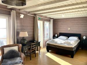 1 dormitorio con cama, escritorio y silla en Bjørnafjorden Hotell, en Osøyro