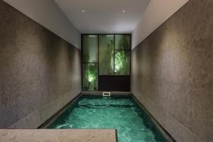 a pool of water in a room with a window at Muralla Sevilla Suites By Lola in Seville