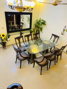 a dining room with a glass table and chairs at Hotel 12 O'clock in Karachi
