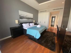 a bedroom with a bed with a blue comforter at Tiara Emerald - 1BR Apartment - Allsopp&Allsopp in Dubai
