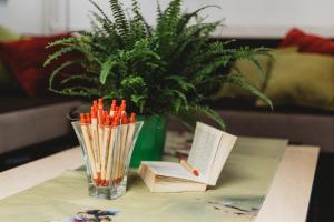 un vase avec des crayons et un livre sur une table dans l'établissement Academic Hostel, à Tallinn