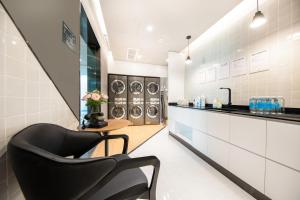 une buanderie avec une chaise et trois lave-linge dans l'établissement Atour Hotel Lianyungang Municipal Affairs Central University Town, à Lianyungang